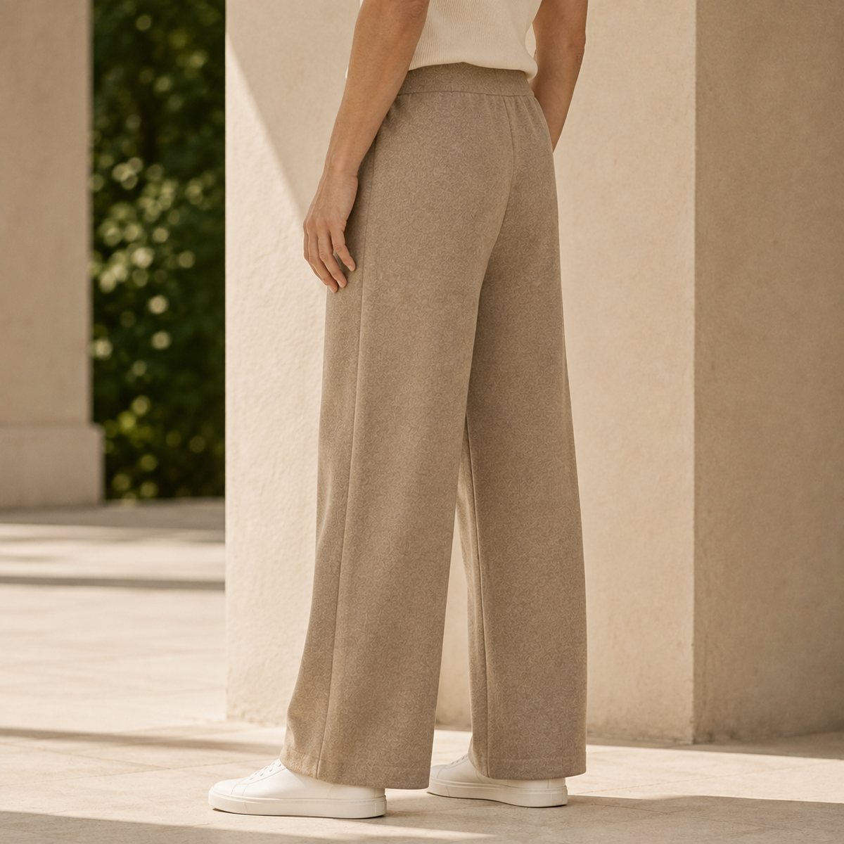 Beige wide-leg merino wool knit pants featuring a relaxed fit and ribbed drawstring waist in a full-length silhouette.