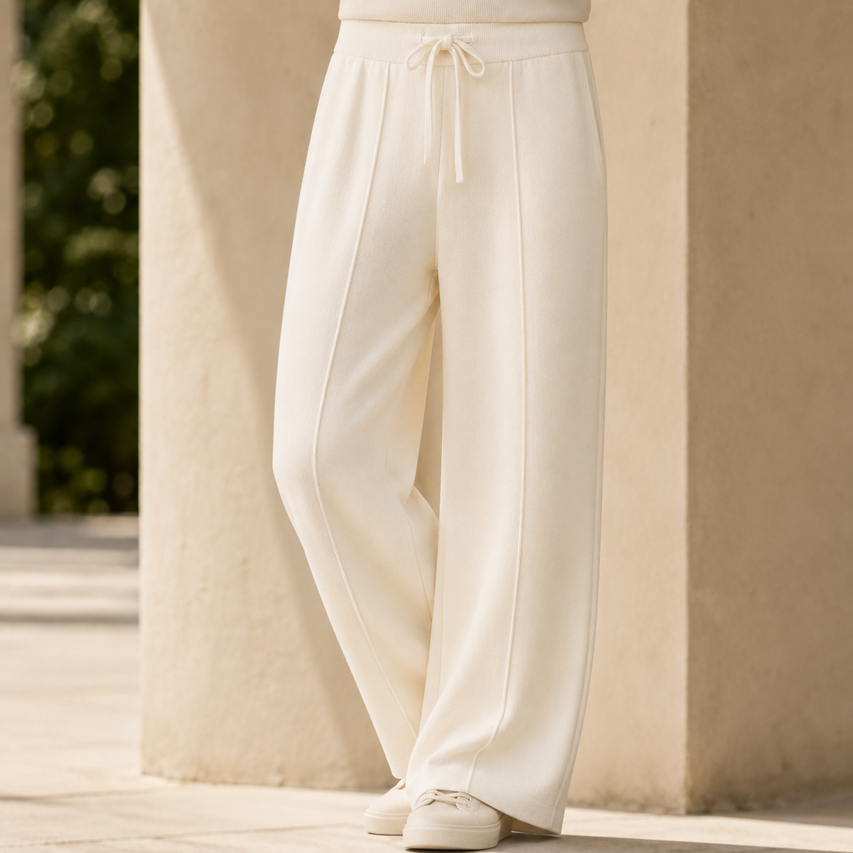 Cream merino wool wide-leg pants featuring a ribbed drawstring waist and soft knit texture in a full-length silhouette.