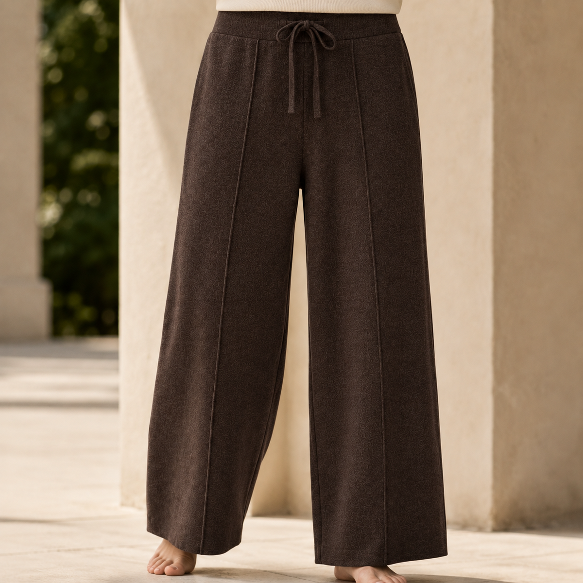 Dark brown wide-leg merino wool pants featuring a ribbed drawstring waist and a soft, full-length knit texture.