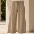 Beige merino wool wide-leg pants featuring a ribbed drawstring waist and clean, full-length silhouette.