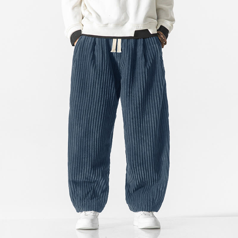 Blue wide-wale corduroy harem pants featuring a drawstring waist, relaxed fit, and tapered ankles with gathered hems.