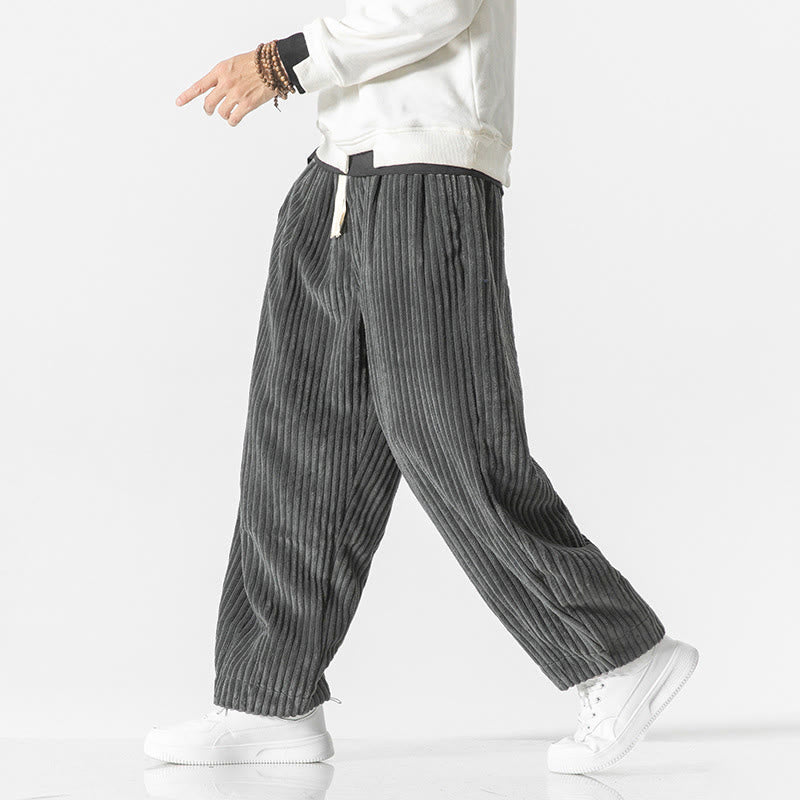 Gray wide-wale corduroy harem pants with a drawstring waist, relaxed fit, and tapered ankles worn with white sneakers.