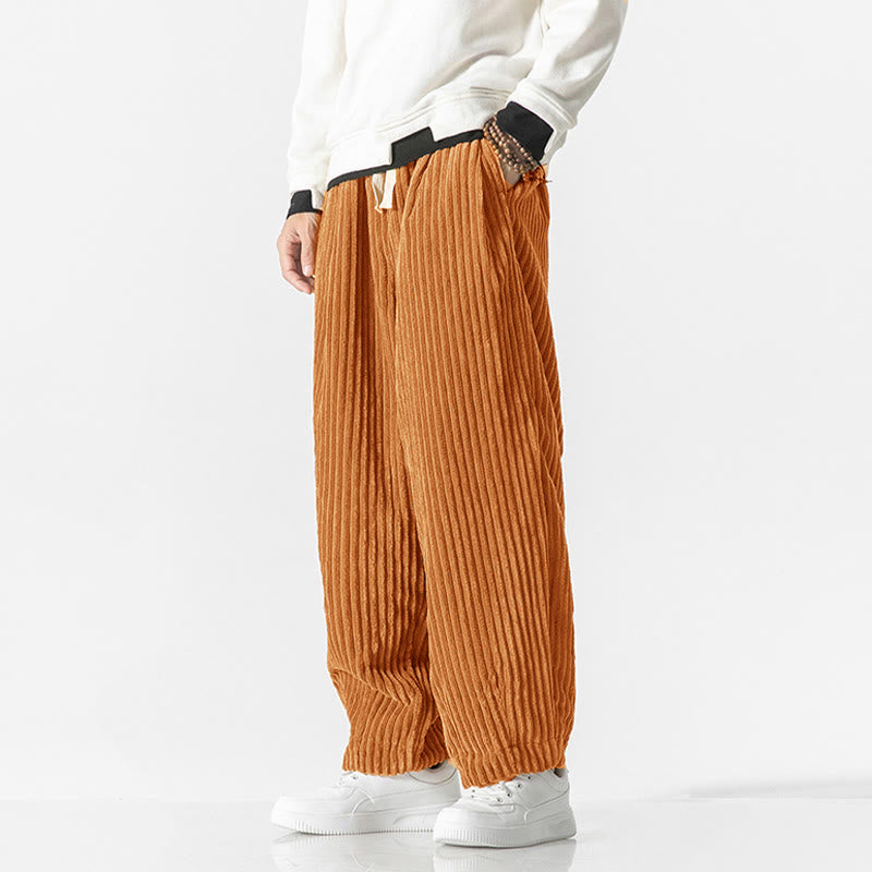 Orange corduroy harem pants in rust orange featuring an elastic drawstring waist and a relaxed, tapered ankle fit.