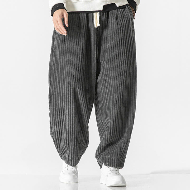 Gray wide-wale corduroy harem pants with an elastic drawstring waist and tapered ankles in a relaxed, voluminous fit.