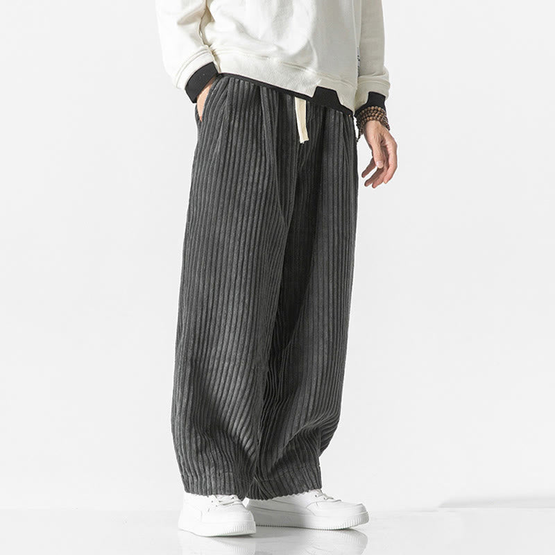 Gray wide-wale corduroy harem pants featuring a drawstring waist, relaxed fit, and tapered ankle with white sneakers.