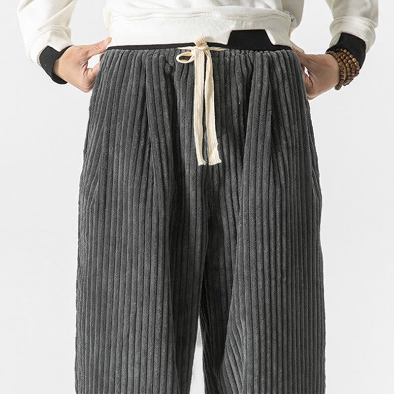 Gray wide-wale corduroy harem pants featuring an elastic drawstring waist and a relaxed, roomy fit.