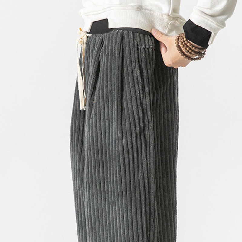 Gray wide-wale corduroy harem pants featuring an elastic drawstring waist and side pockets in a relaxed, roomy fit.