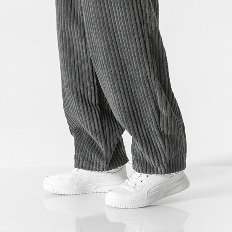 Gray wide-wale corduroy harem pants with a relaxed fit and tapered, gathered ankles worn with white sneakers.