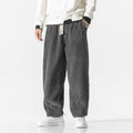 Gray wide-wale corduroy harem pants with a drawstring waist and tapered, gathered ankles.