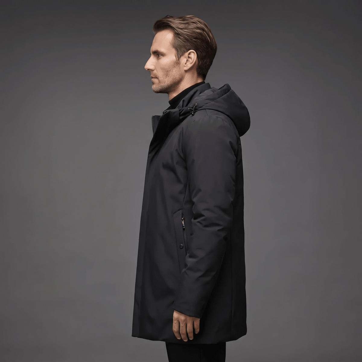 Black wind and water-resistant winter parka with a protective hood and clean, tailored silhouette against a grey background.