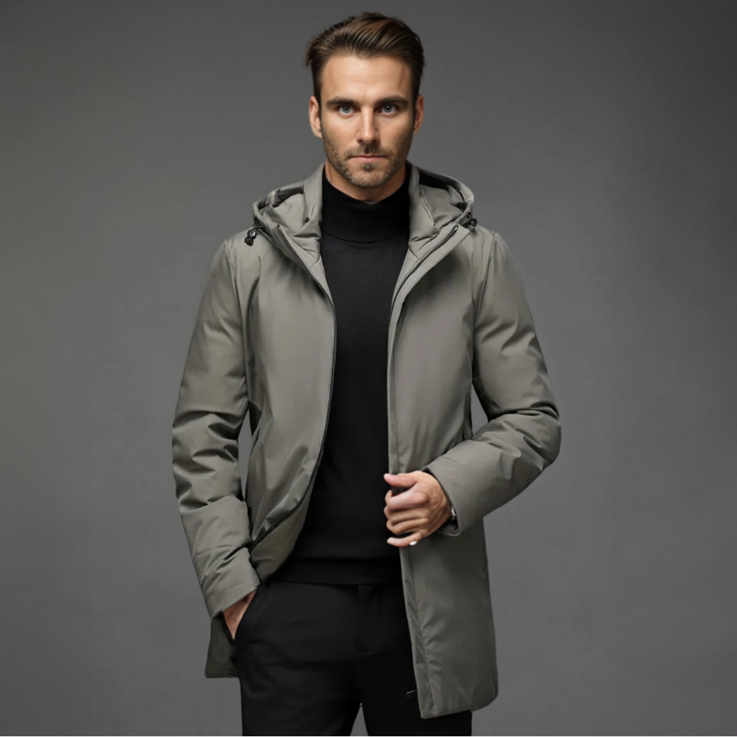 Grey wind-resistant hooded parka with a smooth matte finish, layered over a black turtleneck and trousers.