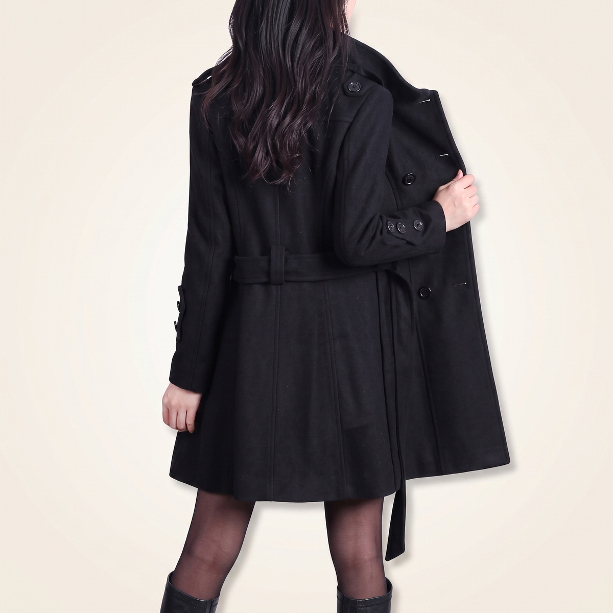 Back view of a woman wearing a black belted wool coat with a flared hem and button-tab cuff details[cite: 8].