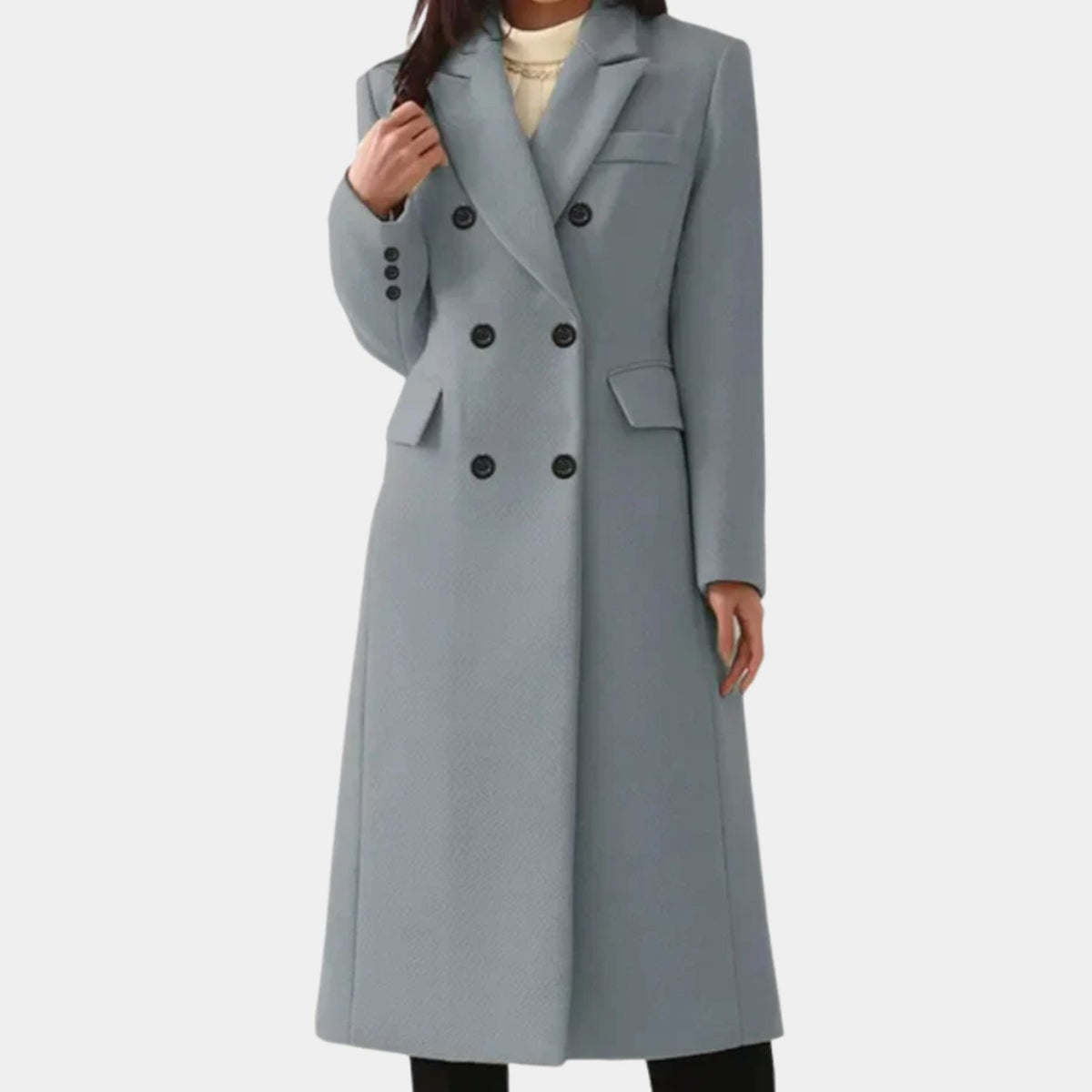 Full-length front view of a woman wearing a light gray double-breasted longline coat with dark front buttons and flap pockets.