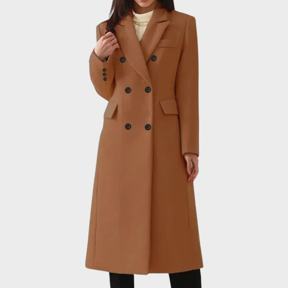 Full-length front view of a woman wearing a warm brown double-breasted longline coat layered over an cream top.