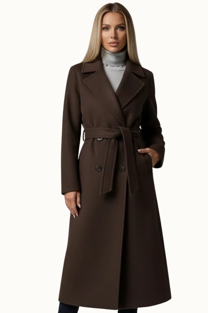 Front view of a woman wearing a dark brown longline double-breasted coat styled over a grey turtleneck sweater.