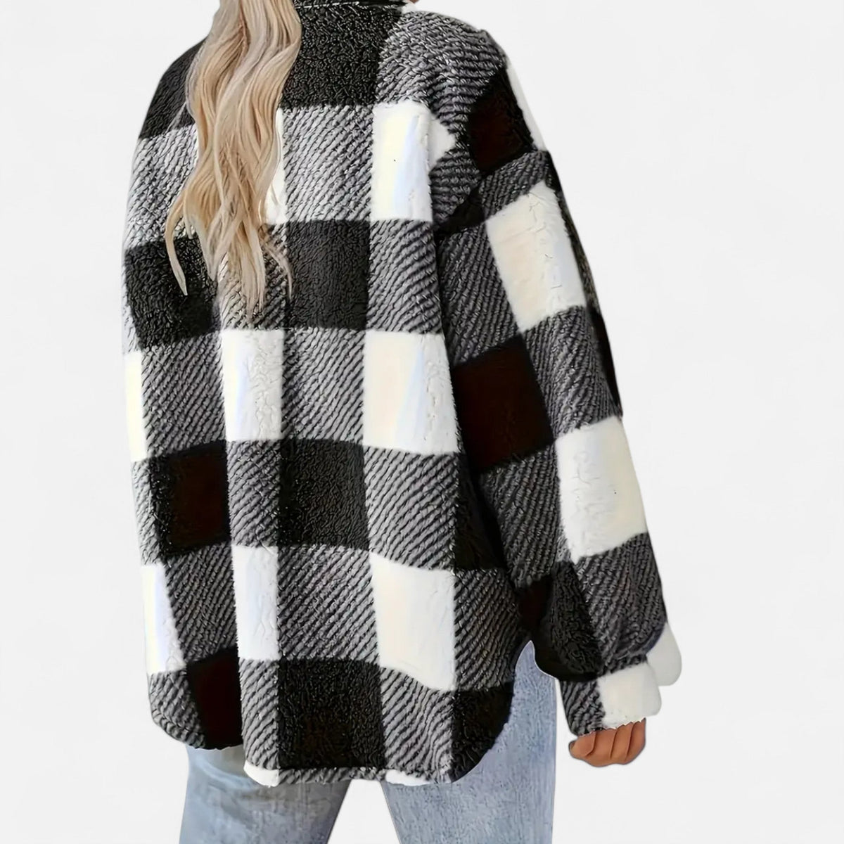 Back view of a woman wearing a black-and-white buffalo check plaid teddy fleece shirt jacket with a rounded high-low hem.