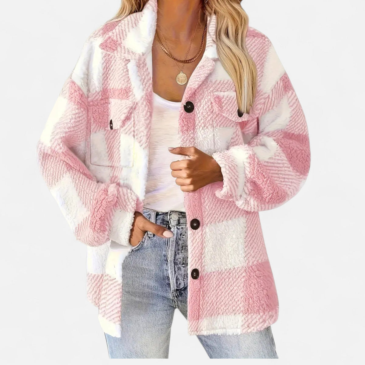 A woman wearing a pastel pink-and-white plaid teddy fleece shirt jacket over a white top and light-wash jeans.