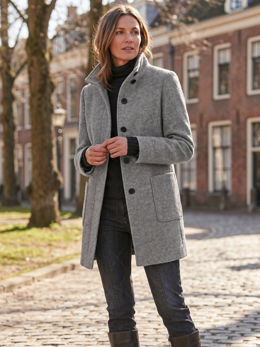 Gray wool-blend coat worn outdoors, showing the full-length silhouette and button closure