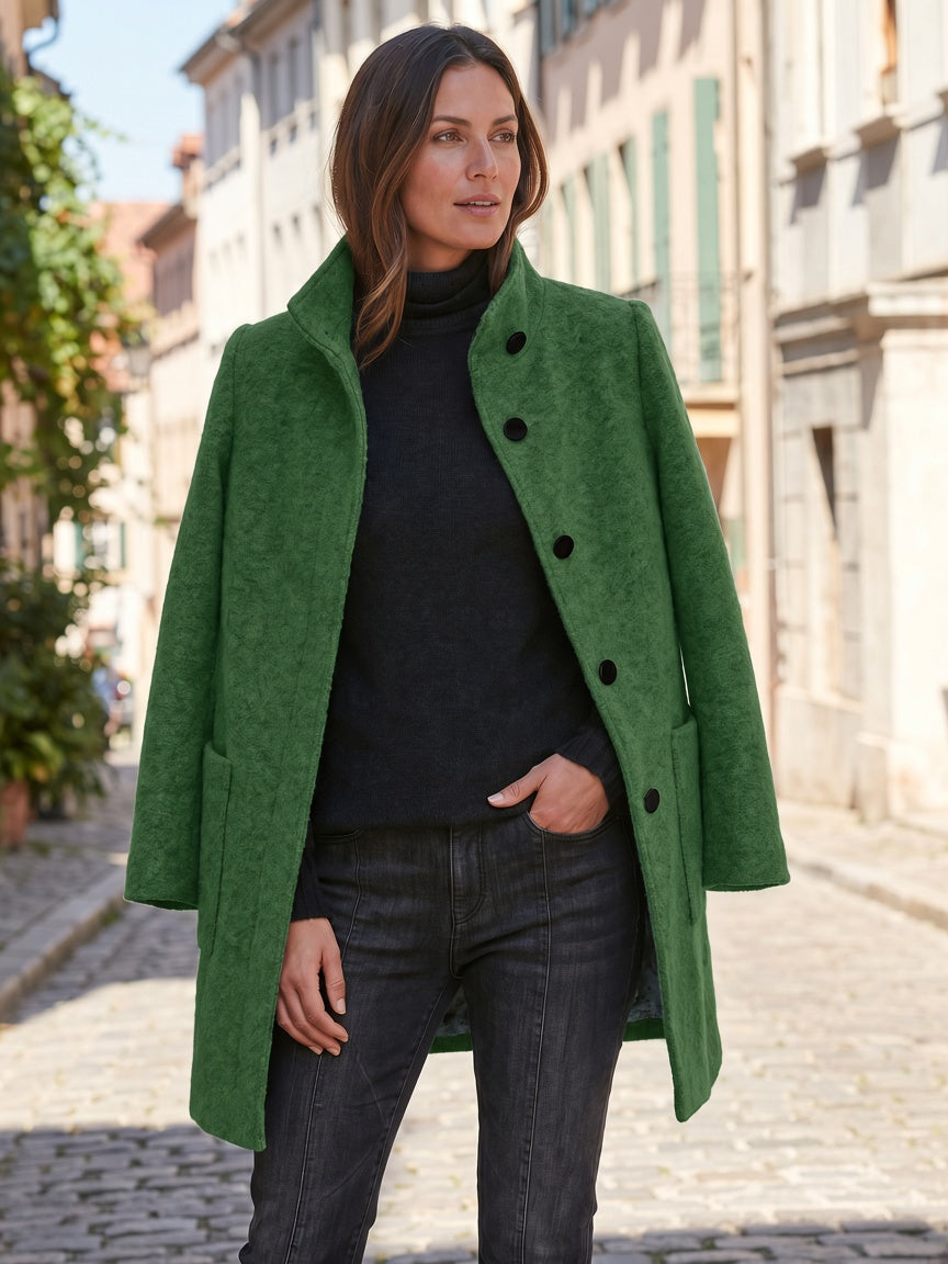 Green women's coat styled with dark clothing and patch pockets
