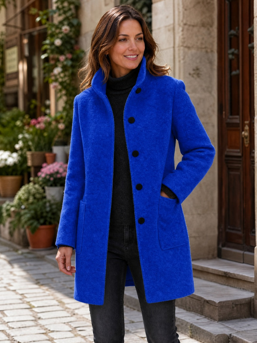 Blue wool-blend coat worn by a woman, featuring a straight fit and button front