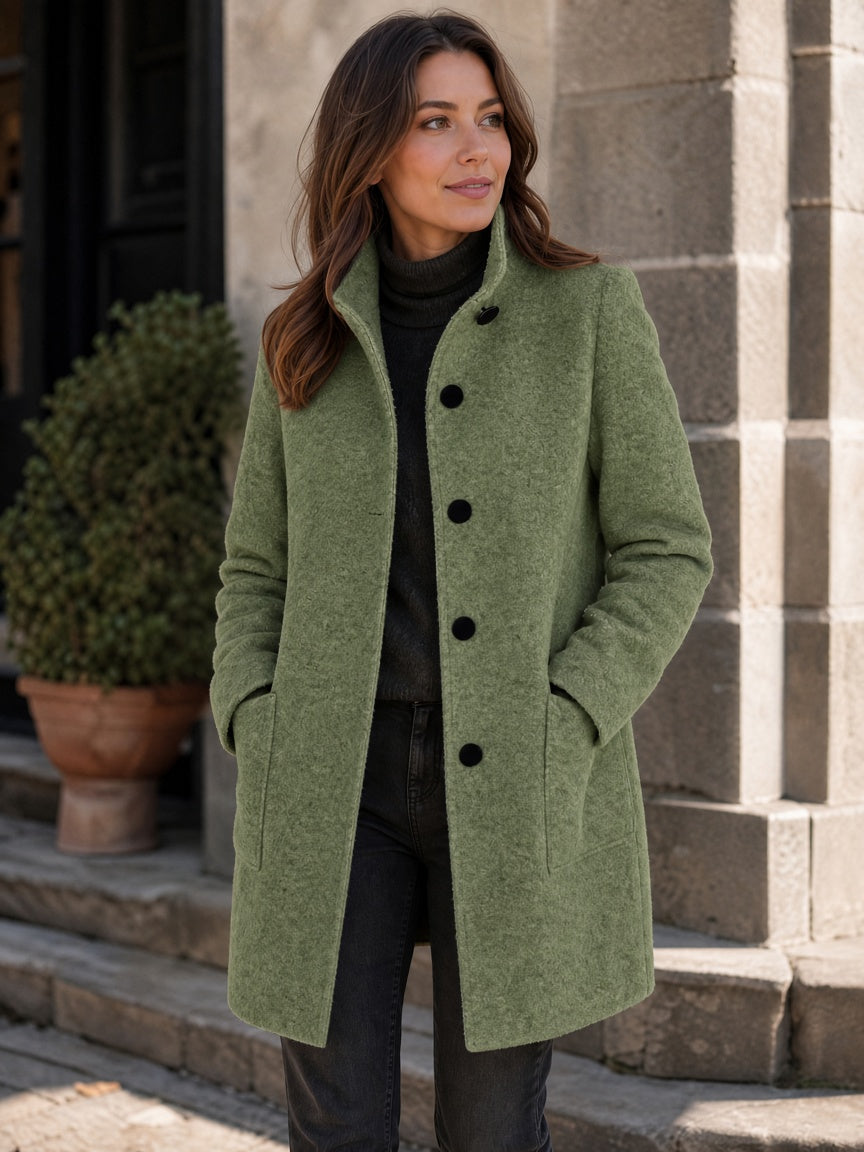 Olive green wool-blend coat worn by a woman, featuring patch pockets and a button closure