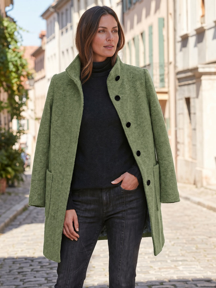Olive green women's coat styled with a black top and dark jeans, showing the straight silhouette