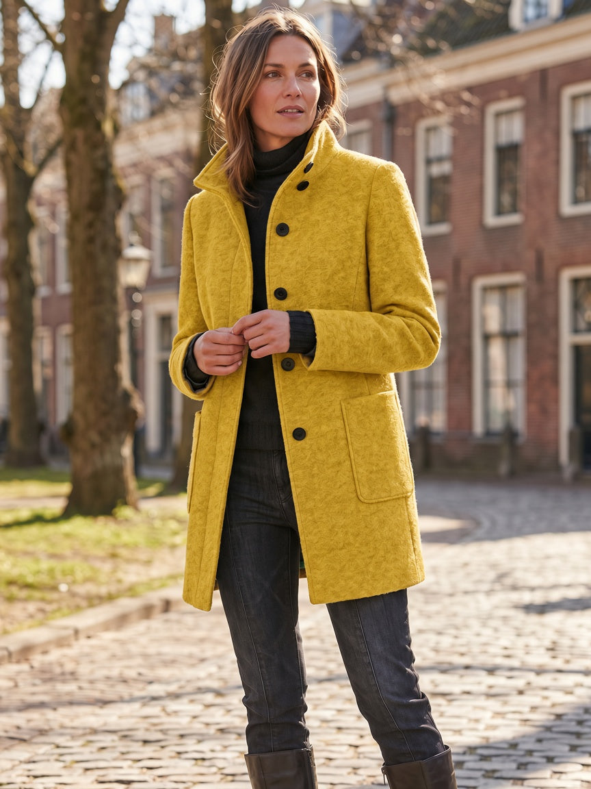 Yellow women's coat worn outdoors, showcasing the straight fit and full-length design