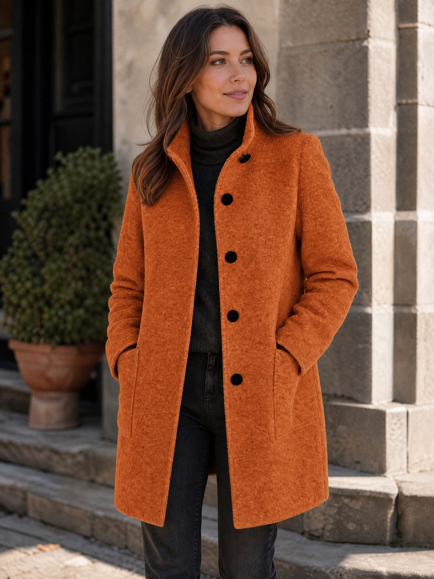 Orange wool-blend coat worn by a woman, featuring a button front and patch pockets