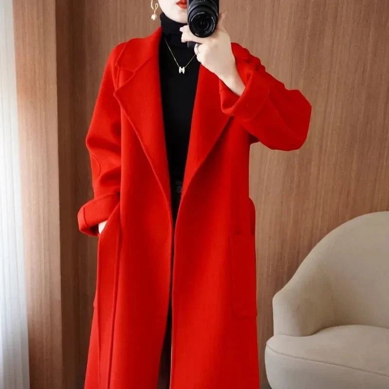 Mirror selfie close-up of a woman wearing a red longline wool-blend coat open over a black turtleneck top, highlighting the collar and lapel structure.