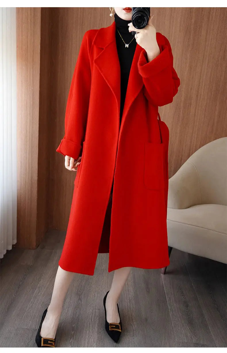Full-length view of a woman wearing an unbelted red longline wool-blend overcoat over a black outfit, showcasing its loose, relaxed drape.