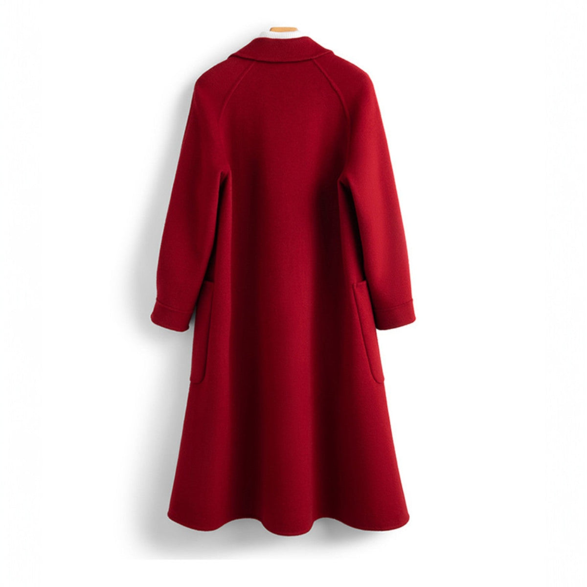 Back view of a women's long red wool coat hanging on a wooden hanger, showcasing a clean tailored back and flared hemline.