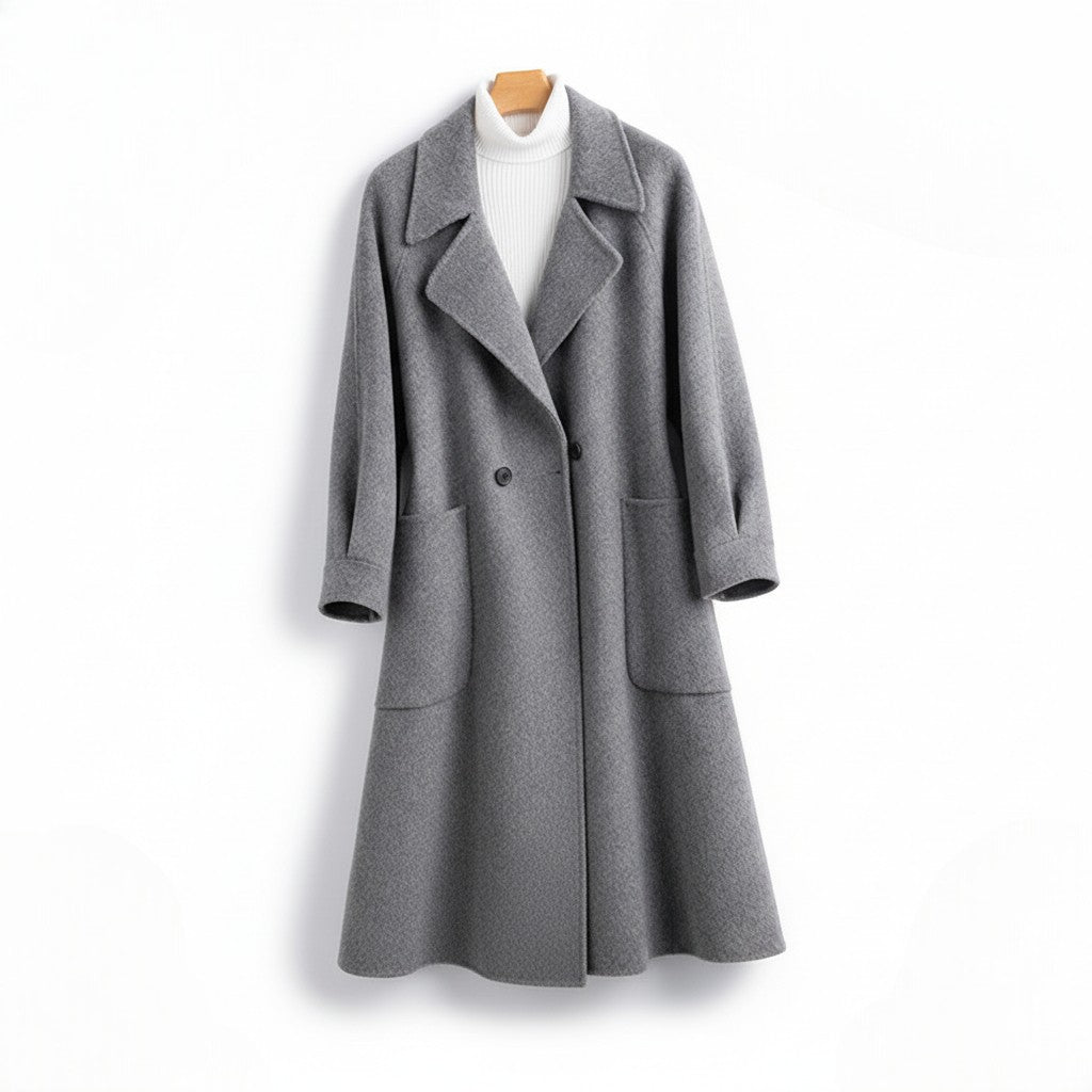 Front view of a women's gray longline wool coat on a hanger with wide lapels, double-breasted buttons, and deep front patch pockets, layered over a white turtleneck.