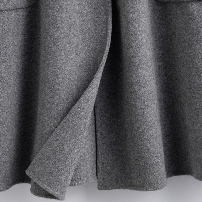 Close-up shot of the bottom hem and back slit vent of the gray wool coat.