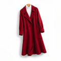 Front view of a women's red longline wool coat hanging on a hanger, featuring wide notch lapels, double-breasted button closure, a relaxed A-line silhouette, large patch pockets, layered over a white ribbed turtleneck top.