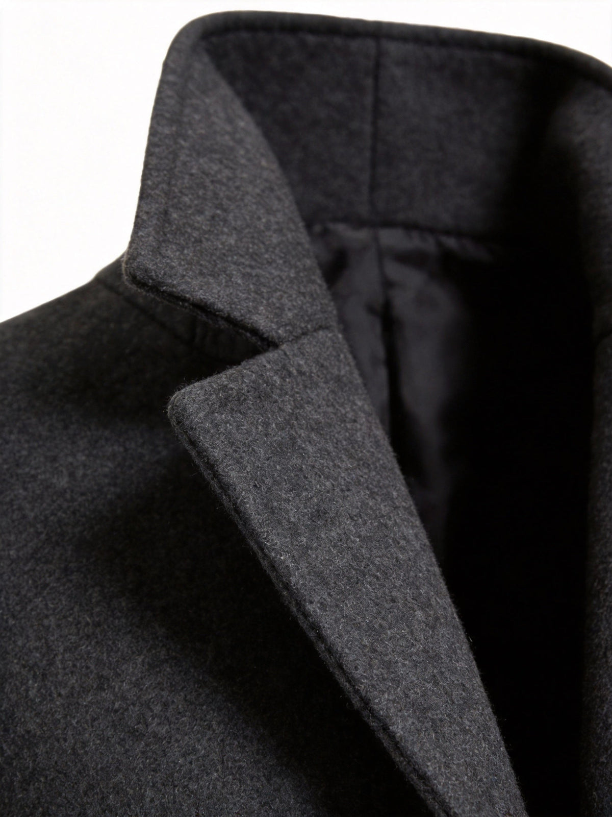 Close-up of the black Wool-Blend Longline Trench Coat showing the structured notch collar and lapel detail.