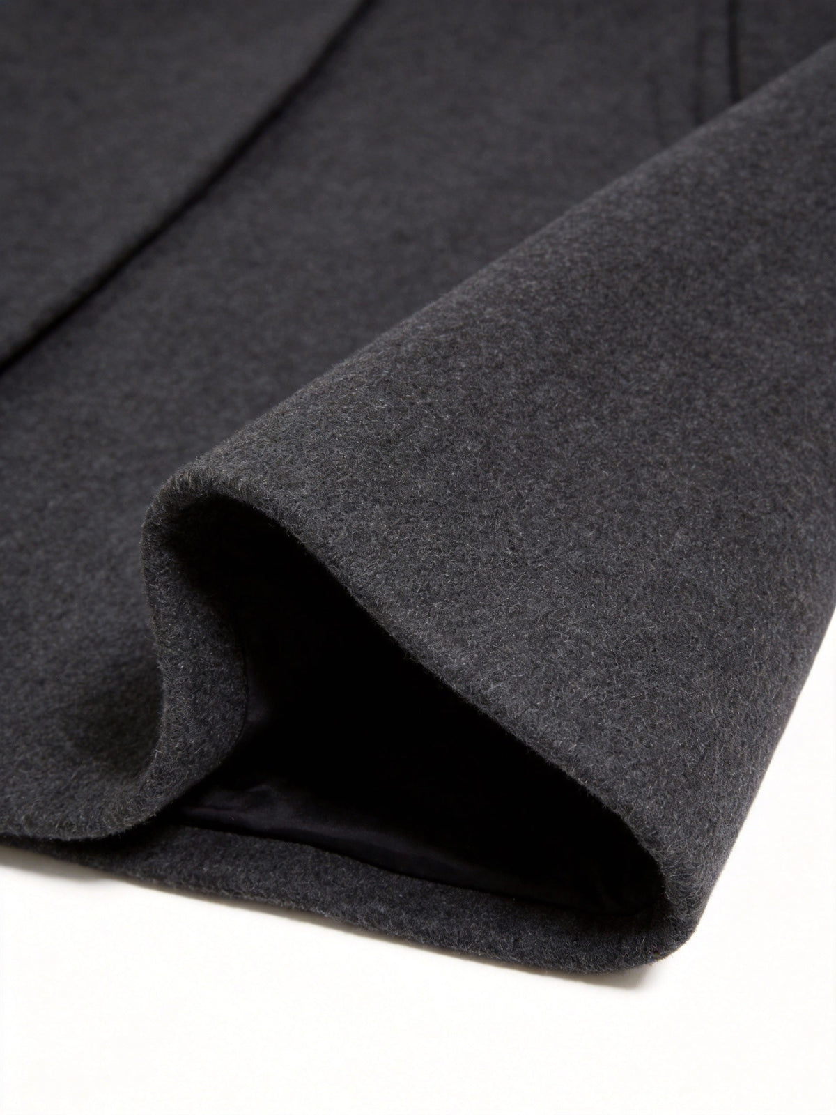 Close-up of the black Wool-Blend Longline Trench Coat hem, highlighting the smooth wool-blend fabric and longline construction.