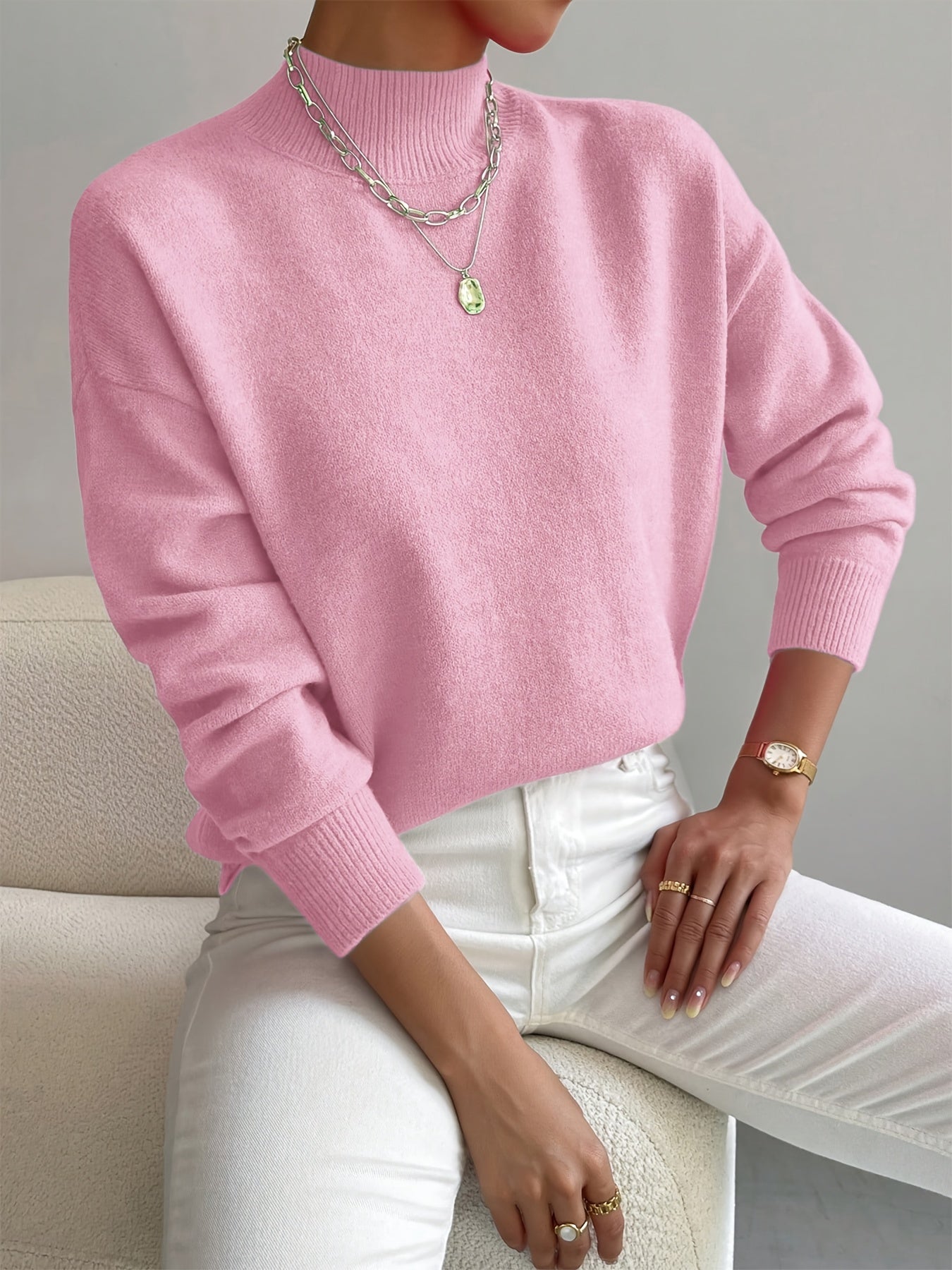 Soft pink knit turtleneck sweater with a relaxed dropped-shoulder fit, ribbed cuffs, and a high neckline.