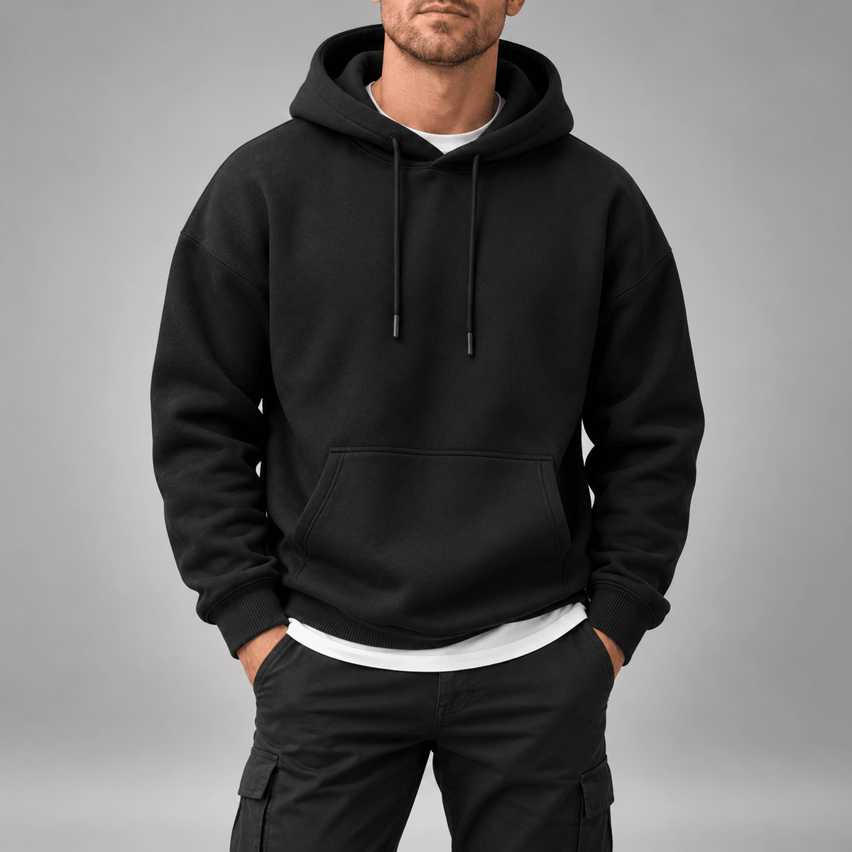 Oversized Fleece-Lined Pullover Hoodie – Black hoodie worn by a male model with dropped shoulders and kangaroo pocket