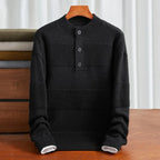 Black cotton henley sweater with textured stripe panels, three-button placket, and ribbed trim in a relaxed fit.