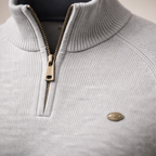 Light grey ribbed knit quarter-zip sweater with a mock neck, raglan sleeves, and a metallic zipper pull.