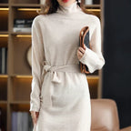 Beige wool midi sweater dress with a high neck, long sleeves, and a waist-defining tie belt in a soft knit texture.