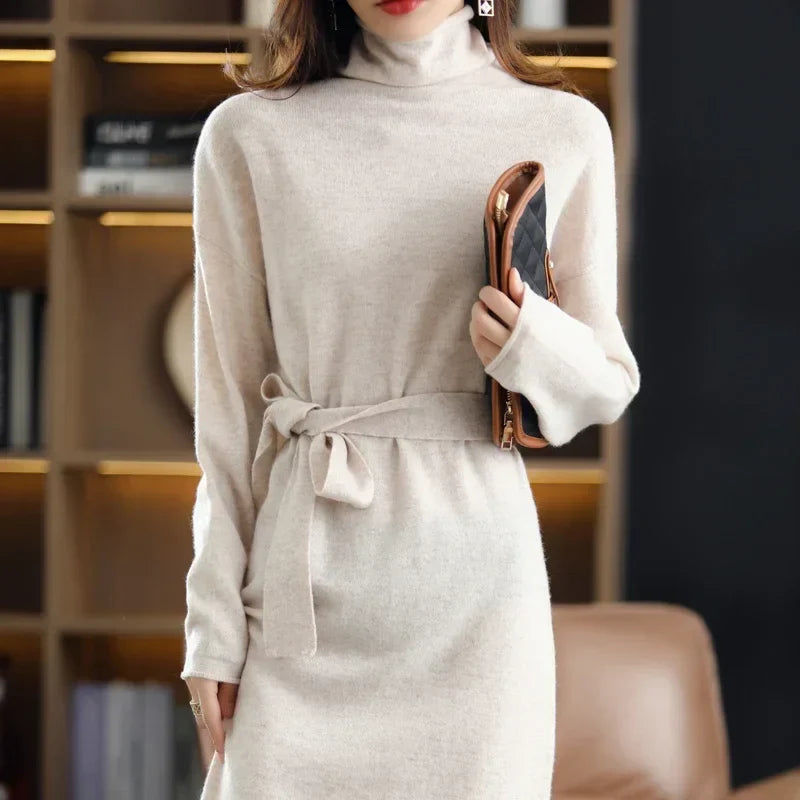 Beige wool midi sweater dress with a high neck, long sleeves, and a waist-defining tie belt in a soft knit texture.