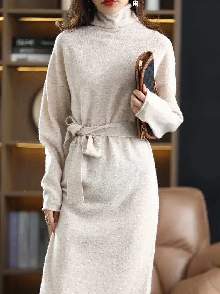 Beige high-neck wool midi sweater dress with a waist-defining tie, featuring a soft knit texture and tailored fit.