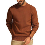 Rust-colored crew neck sweater in a waffle-knit texture with a relaxed fit, ribbed cuffs, and a structured hem.